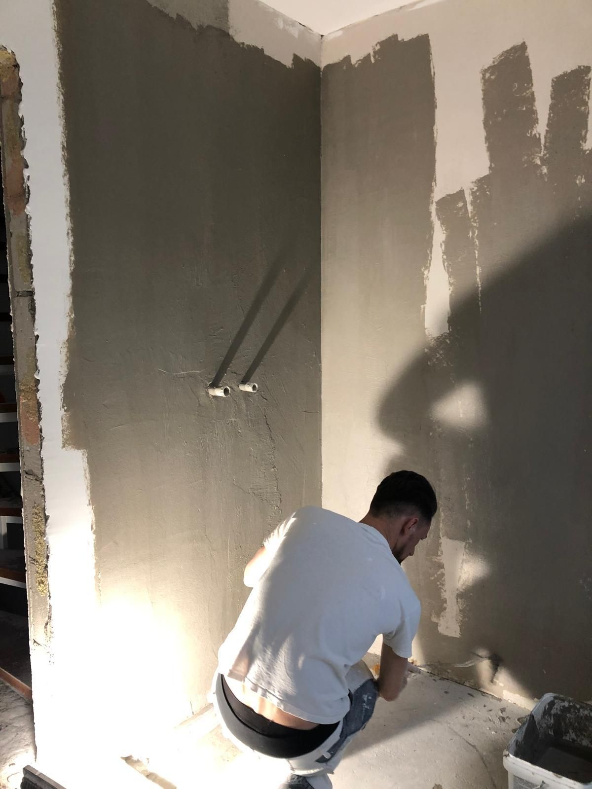 Mitarbeiter bei Spachtelarbeiten an einer Innenwand – Basic GmbH, Servicegebiet Hamburg